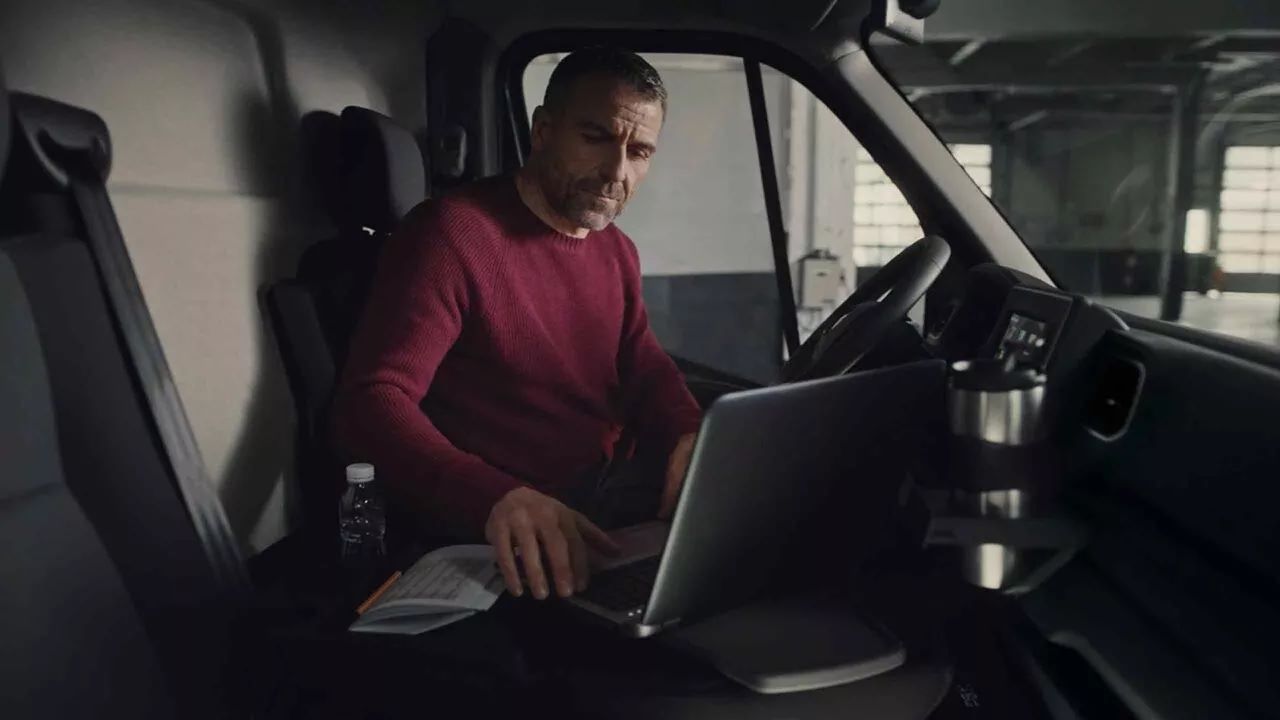 Muž s notebookom v prenajatej dodávke Renault Master